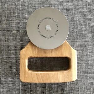 fabric wall installation tool with a disc and large wooden handle