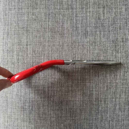 red handle scissors with a bent handle is an upholstery cutting tool.